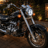 Motorcycle parked on a brick patio with a sunset or sunrise in the background